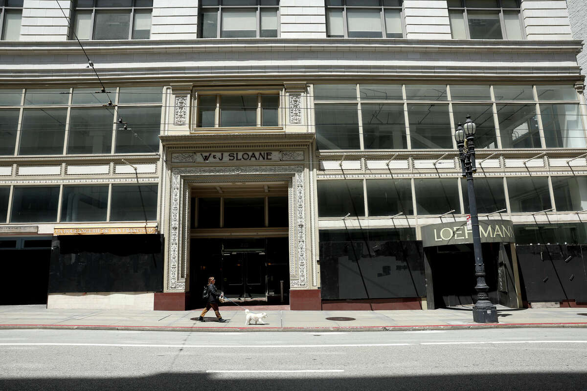 一个行人走过一个空的零售空间在萨特街周二在旧金山。