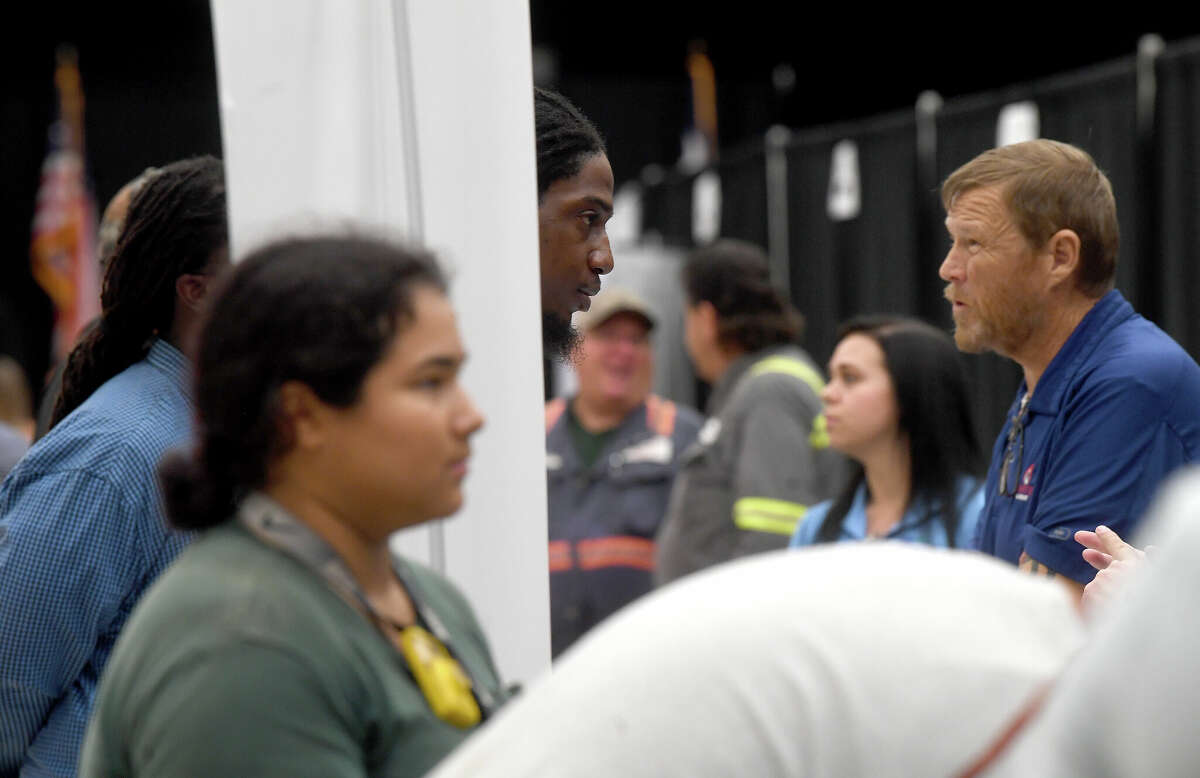 Ambrose Akers (center) talks with an company's representative at the Spring Job Fair hosted by Workforce Solutions at the Bob A. Bowers Civic Center in Port Arthur. Photo made Thursday, May 11, 2023 Kim Brent/Beaumont Enterprise