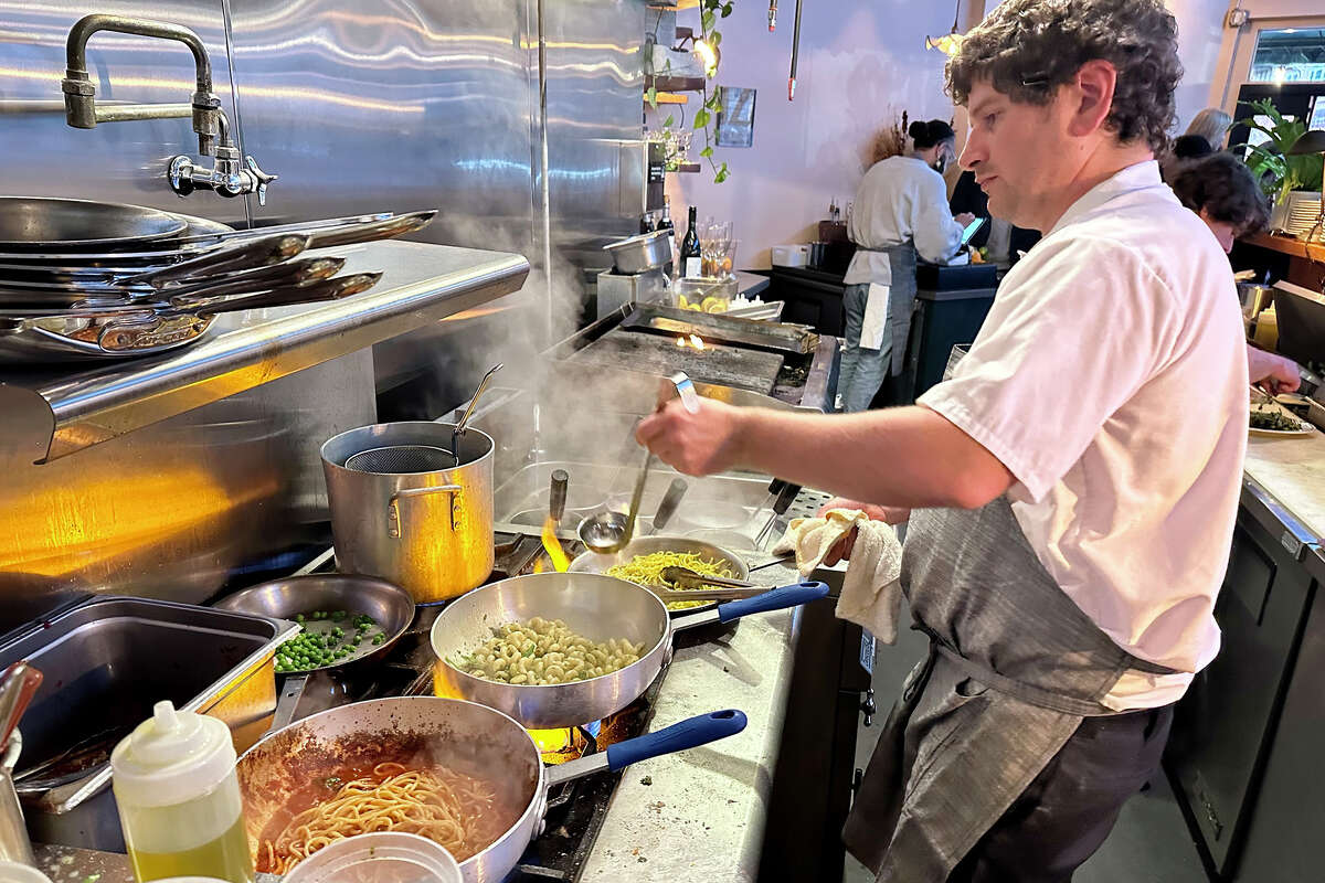Matt Solimano puts the finishing touches on a pesto fusilli inside the open kitchen at Sfizio in Oakland.