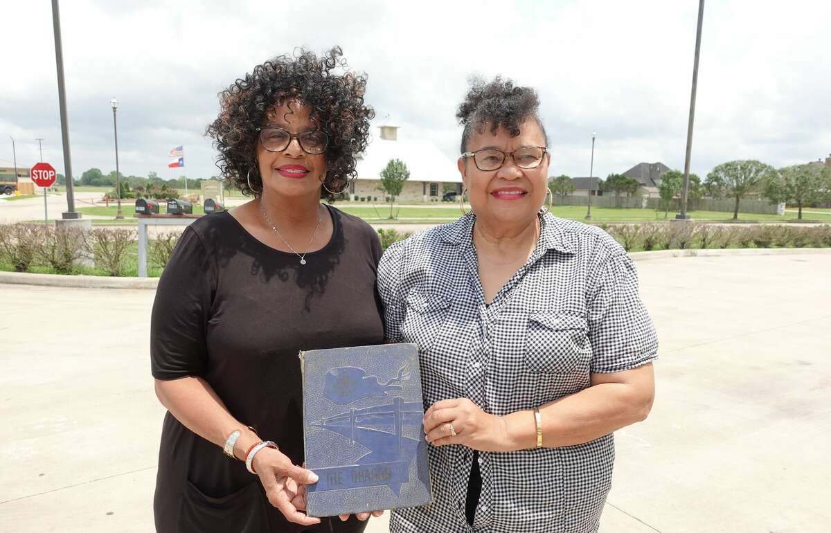 Claudia Tyler, left, and Beverly Carrier-Walters, left, hold a copy of "The Dragon" yearbook of Henderson High School, the school for Black students in China, Nome and Sour Lake before integration of Hardin-Jefferson schools. Photo taken May 11, 2023. Photo by Olivia Malick/ The Enterprise.