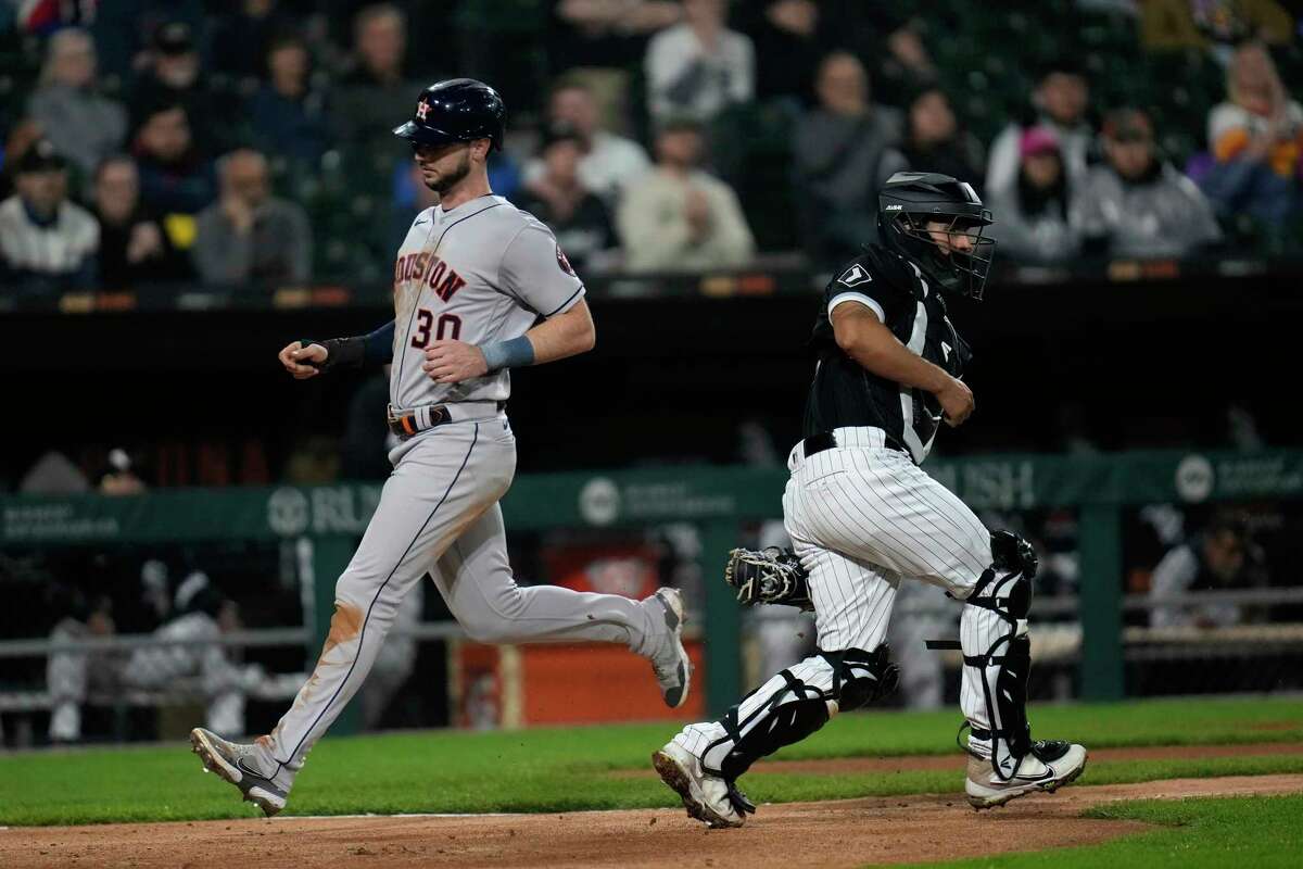 Houston Astros' Kyle Tucker, left, jogs past Chicago White Sox catcher Seby Zavala to score during the fourth inning of a baseball game Friday, May 12, 2023, in Chicago.