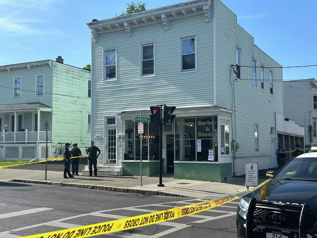 Albany police officers stand outside the barber shop at 221 Second Ave. where two men and a boy were wounded in a shooting on Saturday, May 13, 2023 in Albany.