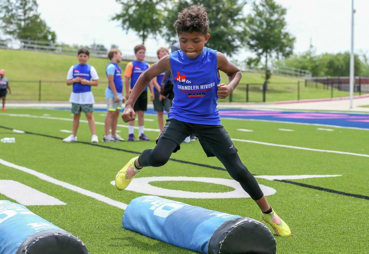 Youth players go through drills Saturday during Chandler Rivers' youth football camp at Beaumont ISD Memorial Stadium.