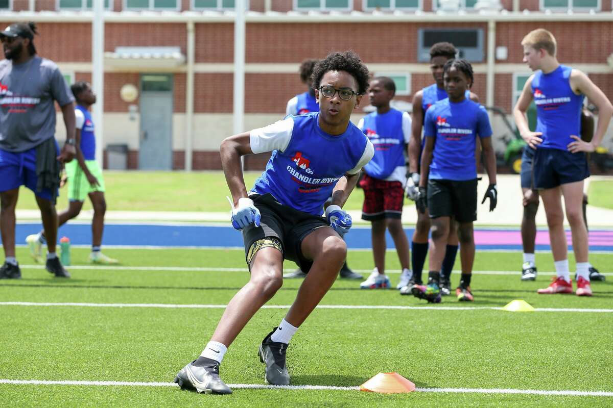 Players go through drills Saturday during Chandler Rivers' youth football camp at Beaumont ISD Memorial Stadium. 