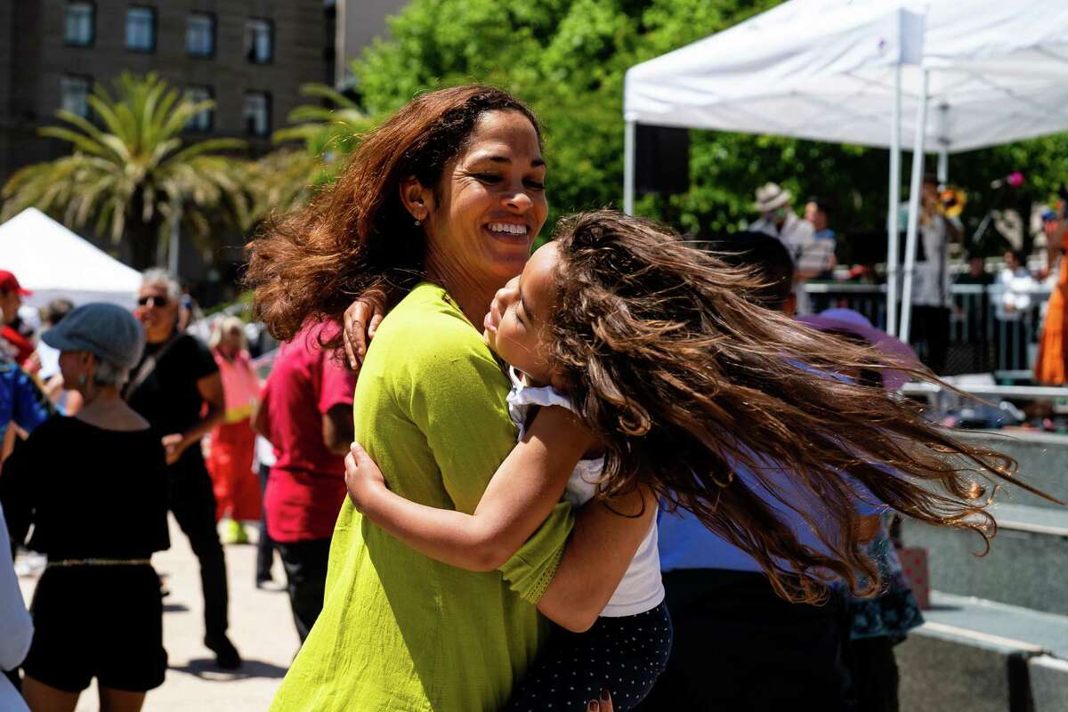 罗莎琳·阿科斯塔(左)和她的女儿在旧金山联合广场的母亲节活动上跳舞，这是为期夏季的“盛开的联合广场”促销活动的序幕。