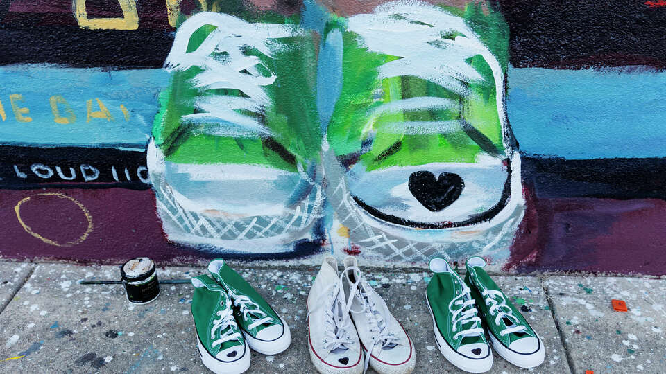 Three pairs of Converse Chuck Taylor All Star Hi-Tops sit under the mural honoring 10-year-old Maite Yuleana Rodriguez, one of the 21 people killed in the May 24 Robb Elementary School shooting, in Uvalde, Texas, Tuesday, July 26, 2022. Maite's mother Ana Rodriguez drew black hearts on the shoes to match what the fourth grader was wearing when she died as a gift for the San Antonio based artists Ana Hernández and Gabi Magaly, who worked on the mural.