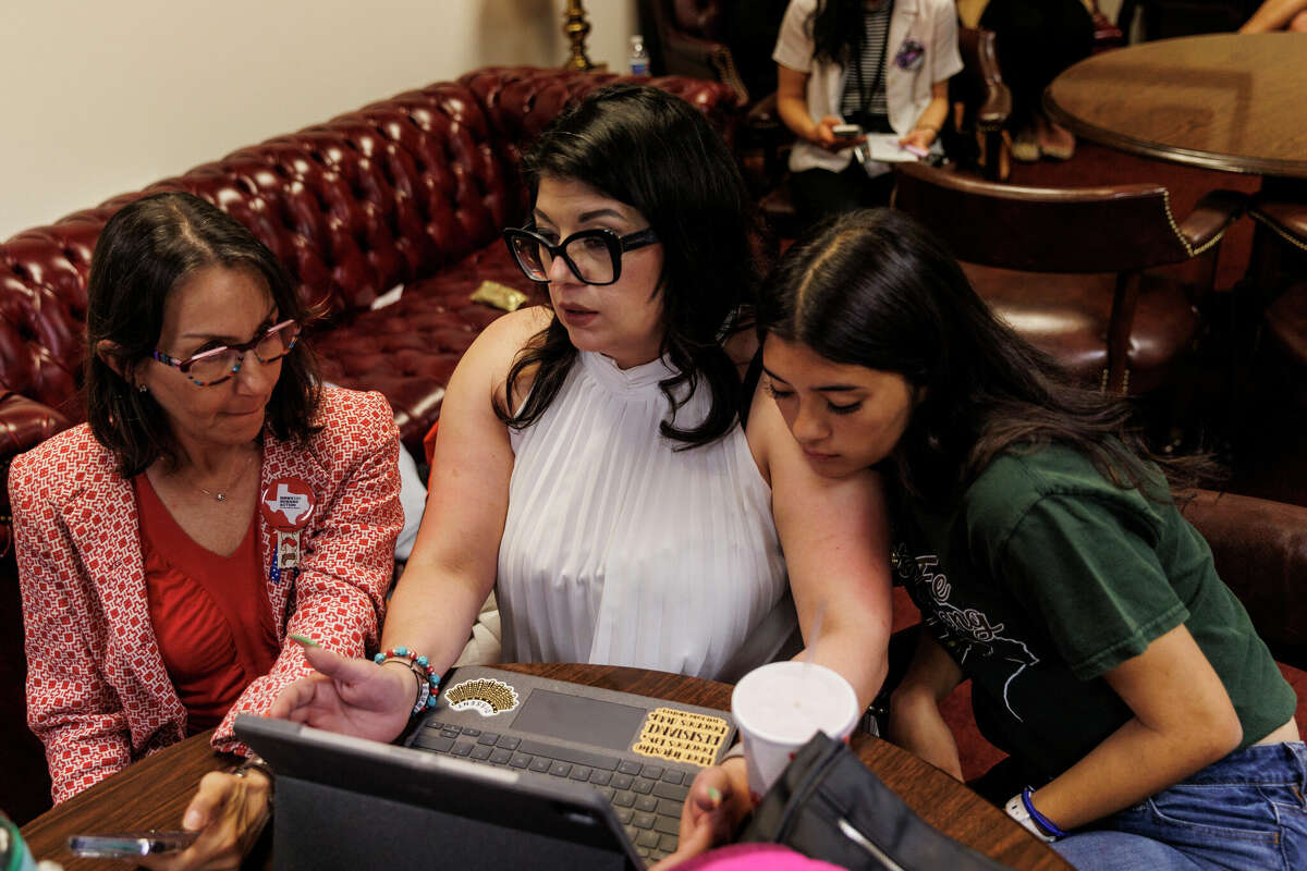 Danna Halff, gun policy coordinator for Sen. Roland Gutierrez, from left, talks with Christina Delgado, a Texas advocacy associate for the Community Justice Action Fund, and her daughter London Delgado, 18, as they wait for the House Community Safety Committee start up again at the state capitol in Austin, Tuesday, April 18, 2023.