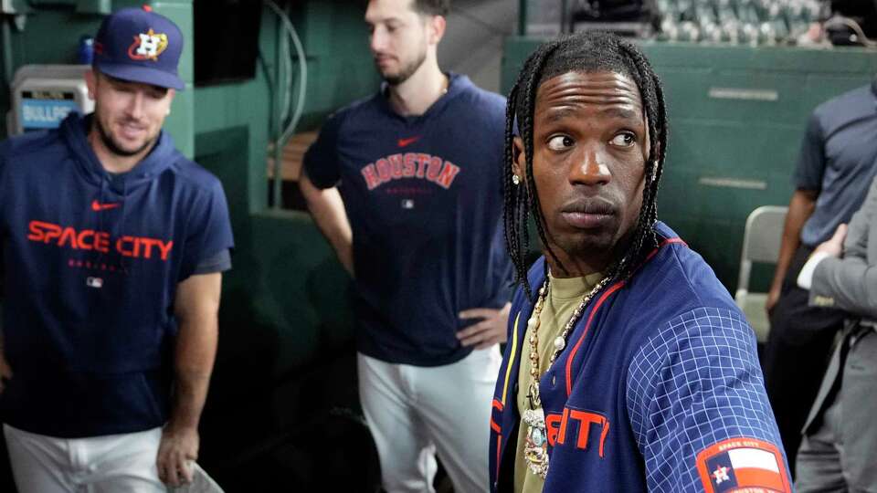 Houston rapper Travis Scott, right, is joined by Houston Astros Alex Bergman, left, and Kyle Tucker, as he waits to hit before a baseball game between the Chicago Cubs and Houston Astros Monday, May 15, 2023, in Houston. (AP Photo/David J. Phillip)