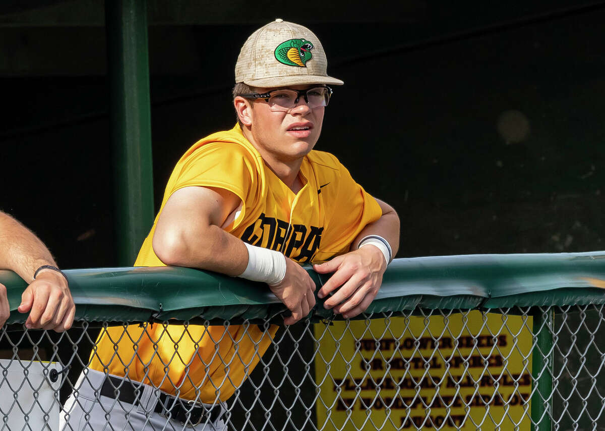 Will Clark looks out from a dugout before a baseball game between