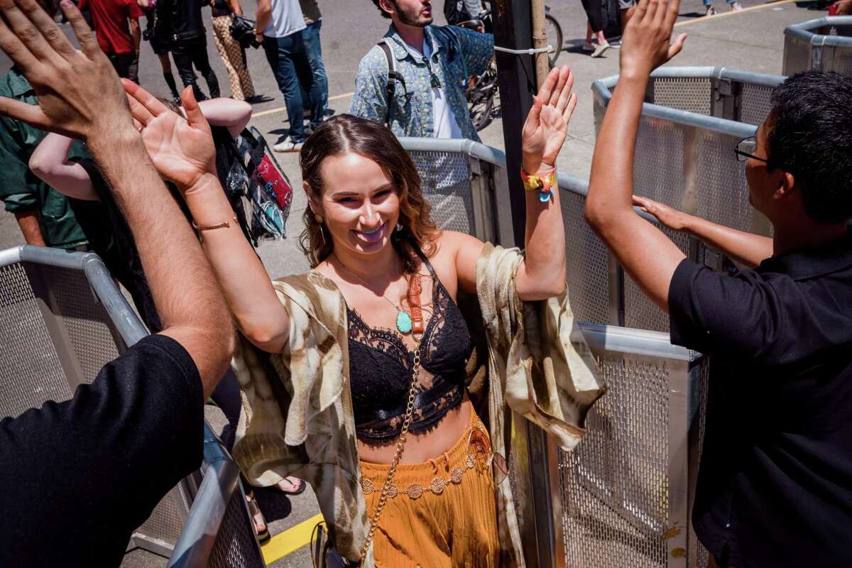 A  BottleRock Napa Valley attendee high-fives festival staff upon entering the first day of the event on May 27, 2022.