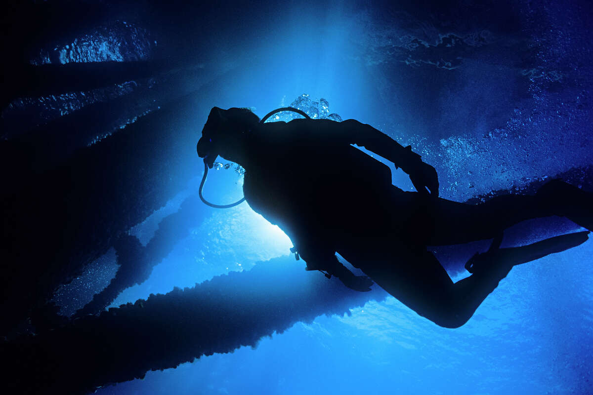 A commercial diver inspects underwater infrastructure. 