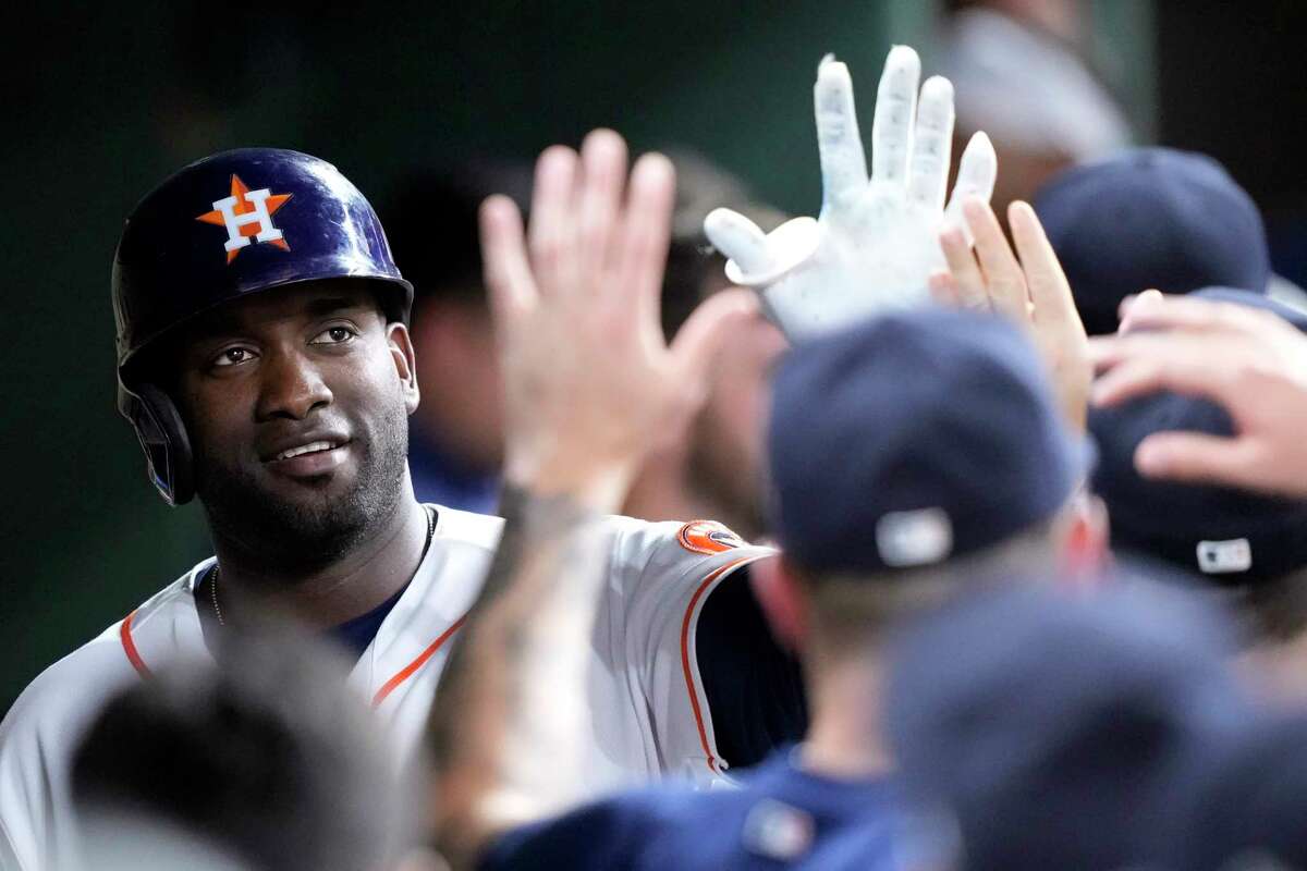Houston Astros' Yordan Alvarez, left, celebrates in the dugout after scoring a run during the fourth inning of a baseball game against the Chicago Cubs Tuesday, May 16, 2023, in Houston.