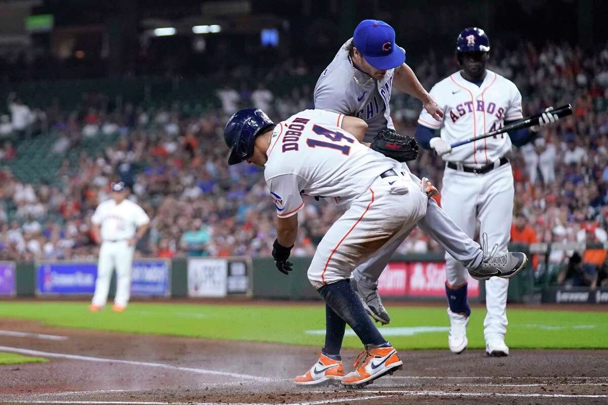 Houston Astros' Mauricio Dubon (14) scores as Chicago Cubs starting pitcher Justin Steele covers home plate after throwing a wild pitch during the first inning of a baseball game Tuesday, May 16, 2023, in Houston.