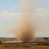 A dust devil, just like the one pictured, formed during a baseball game and engulfed the young catcher. 