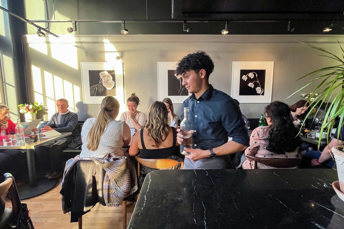 A server carries a bottle of water at Marlena in San Francisco on May 16, 2023.