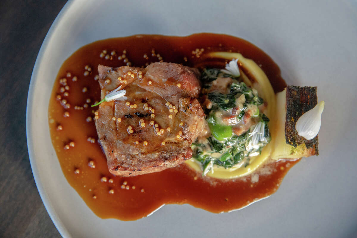 Grilled Sakura Pork Collar with creamed fava leaf, fava bean, and potato terrine at Marlena in San Francisco, Calif. on May 16, 2023.