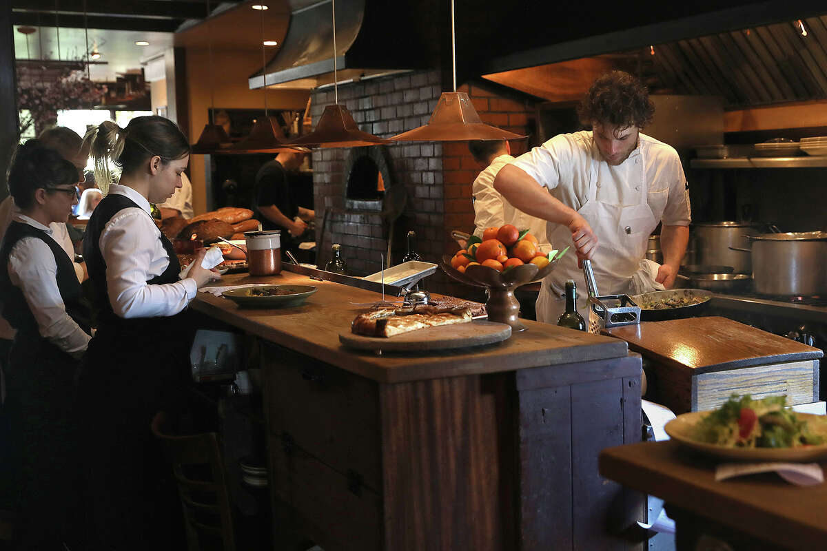 FILE: Saute chef Caleb Peyton, right, seen upstairs at Chez Panisse on Wednesday, Feb. 20, 2019, in Berkeley, Calif. 