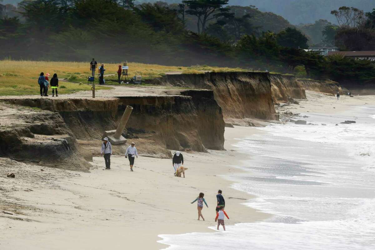 人们在半月湾冲浪者海滩摇摇欲坠的悬崖边散步。最新研究发现，海平面上升和风暴加剧可能导致该州许多标志性海滩在本世纪末消失。