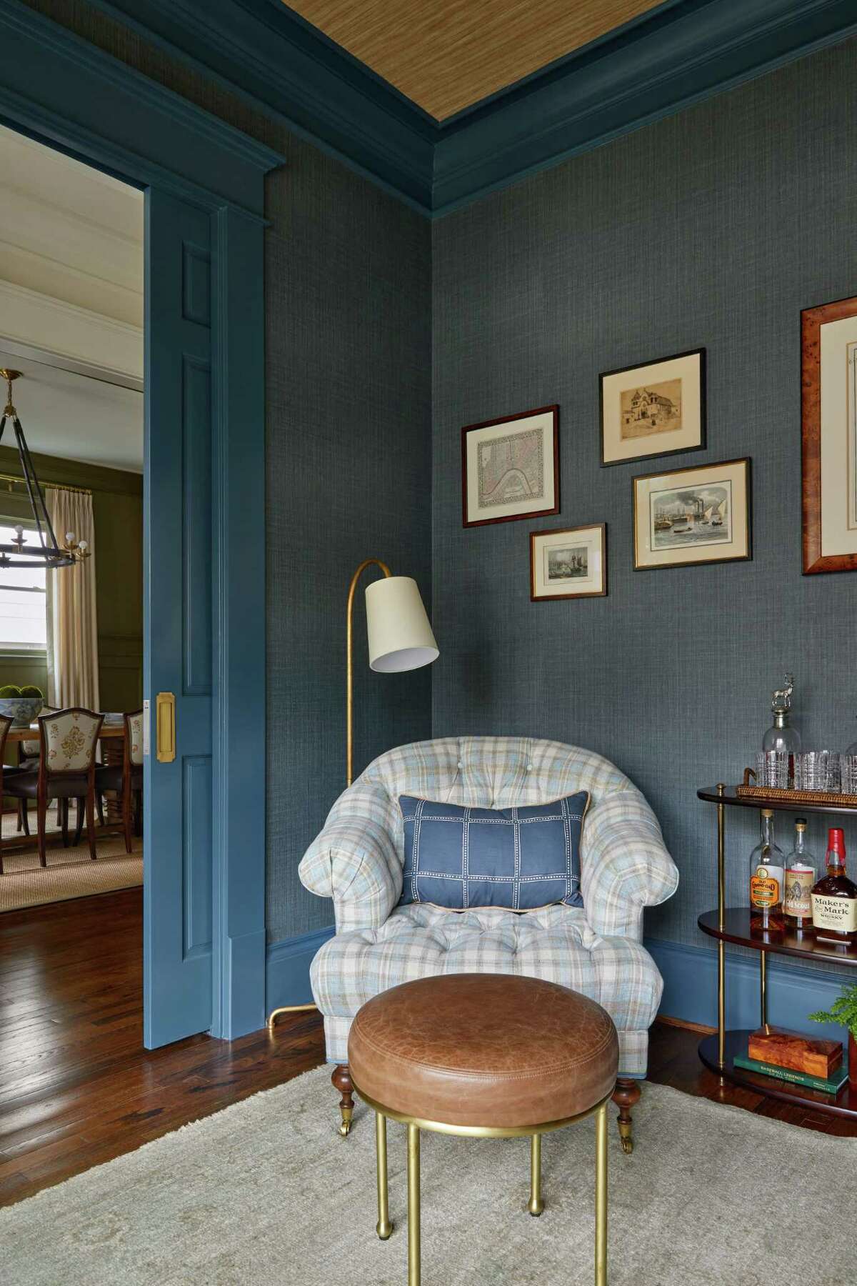 Vinyl grasscloth wallpaper and dark blue-green trim decorate the office/library.