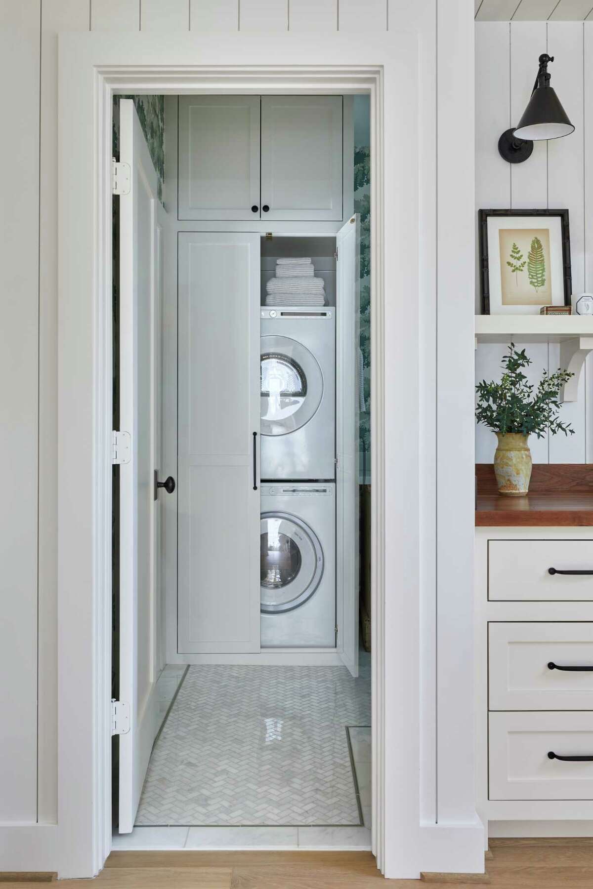 A closet with a stacked washer and dryer is part of the apartment's bathroom.