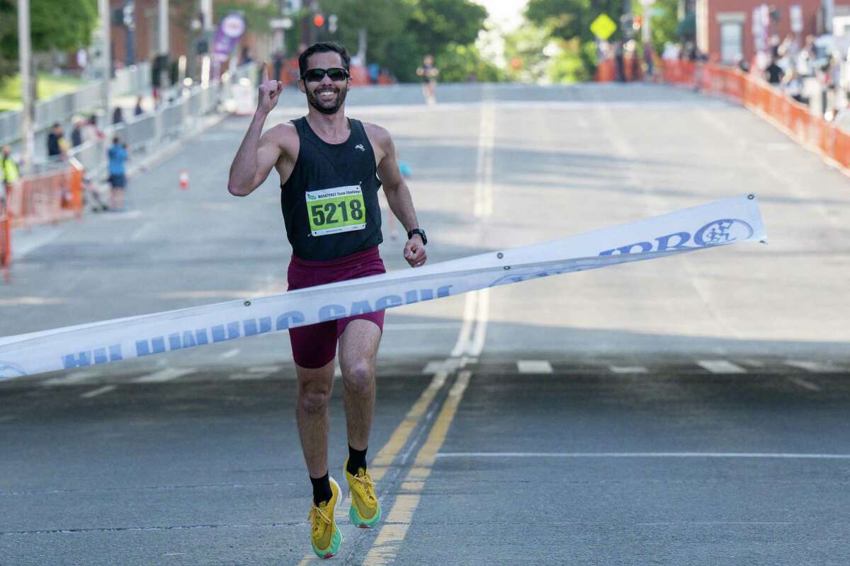 Ricardo Estremera, of Albany, the first-place men’s finisher, crosses the finish line with a time of 16:51 in the 2023 CDPHP Workforce Team Challenge, the largest running event in the Capital Region, on Thursday, May 18, 2023, in Albany NY.