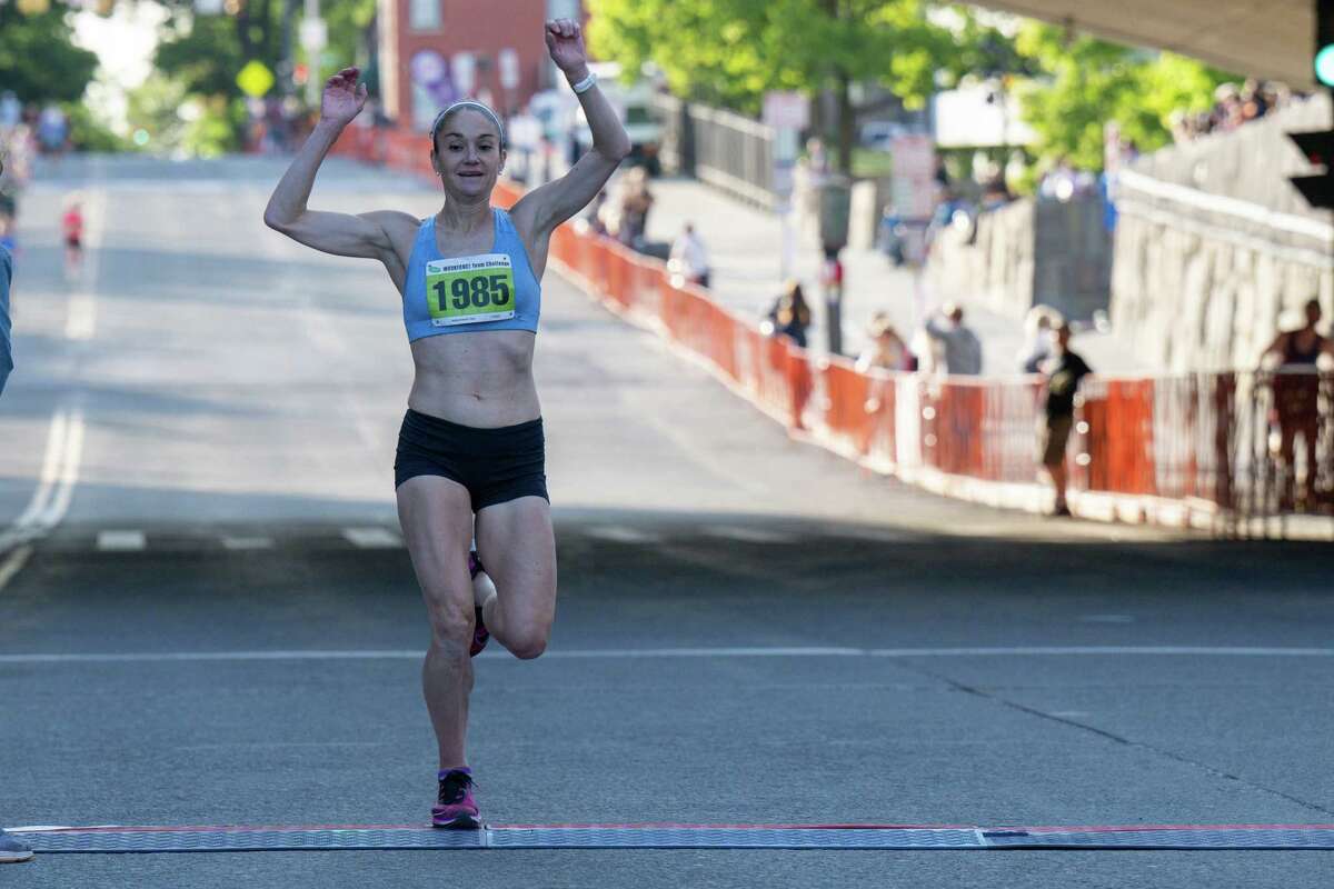 Karen Bertasso-Hughes, of Selkirk, the first-place women’s finisher, crosses the line with a time of 20:14 in the 2023 CDPHP Workforce Team Challenge, the largest running event in the Capital Region, on Thursday, May 18, 2023, in Albany NY.