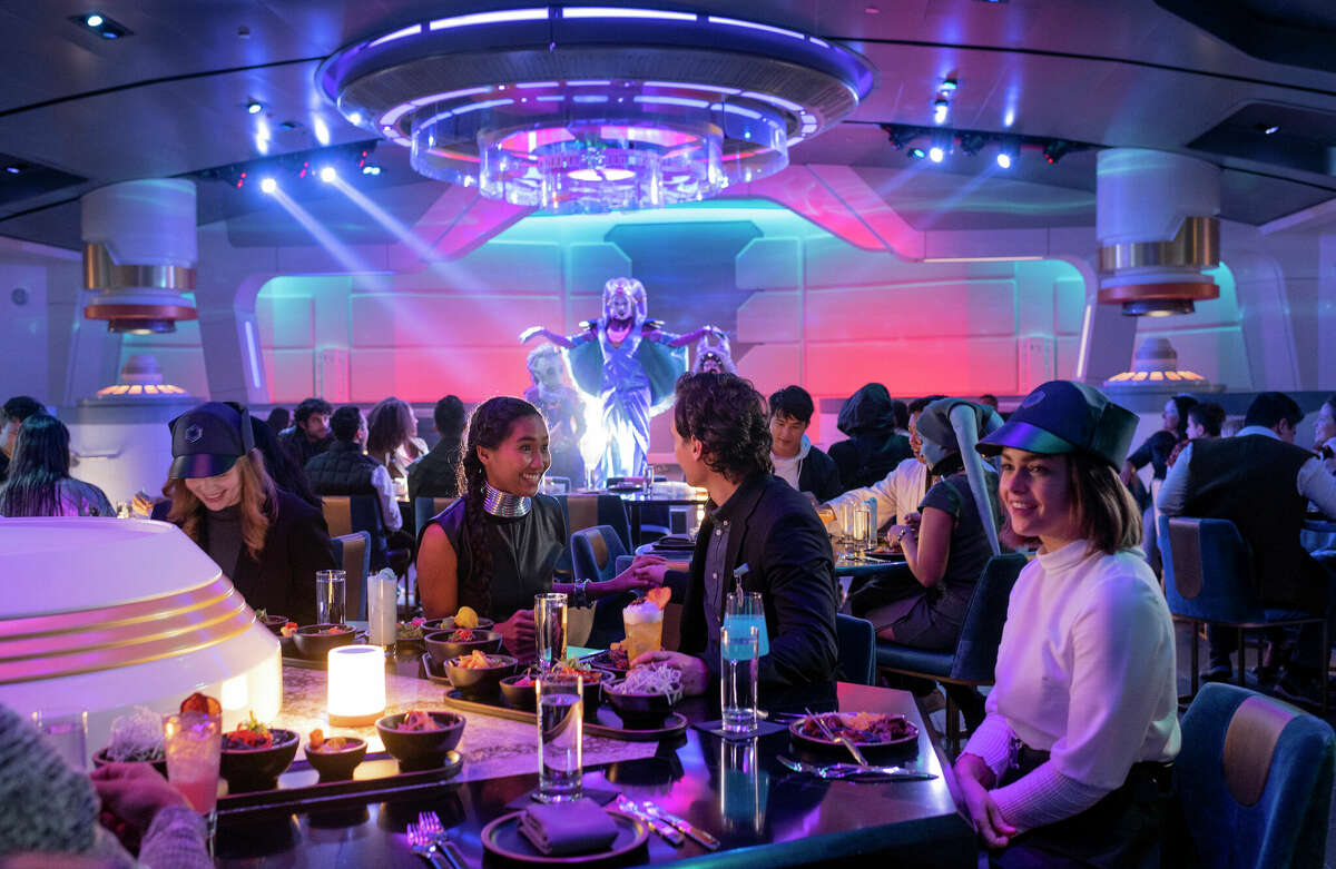 Guests enjoy a meal and performance by Gaya in the Crown of Corellia Dining Room onboard the Star Wars: Galactic Starcruiser, an immersive hotel at Walt Disney World Resort in Lake Buena Vista, Fla.