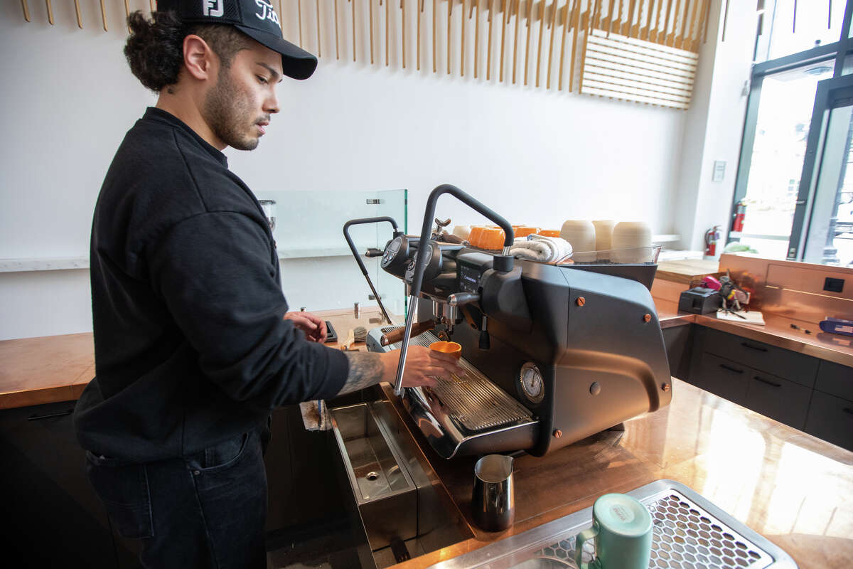 Barista Mehdi Chung makes a latte at the new Caffè by Mr. Espresso on Broadway in downtown Oakland, Calif., on May 18, 2023.