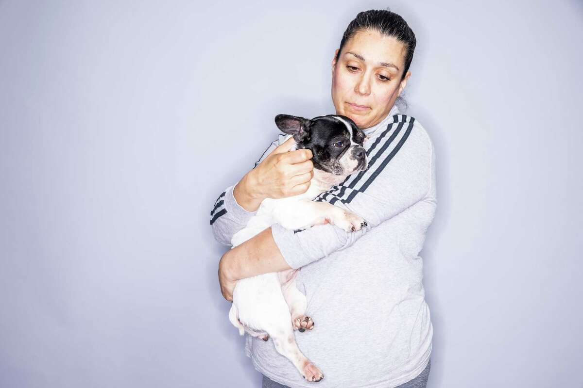 Susan Sanchez holds Shadow, her French bulldog, at her home in San Bruno. Sanchez said Shadow had deep lacerations on her back after Wag Hotels staff failed to remove her brace during a stay at the San Francisco facility in 2022.