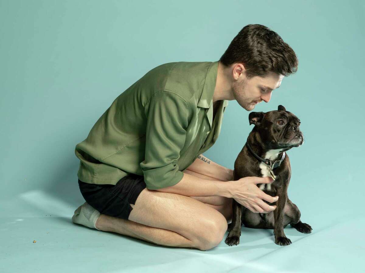 Carter Shults sits with Brutus, his French bulldog, who he says came home with his paw pads scraped off after visits in 2020 and 2021 to a Wag Hotels location in Hollywood.