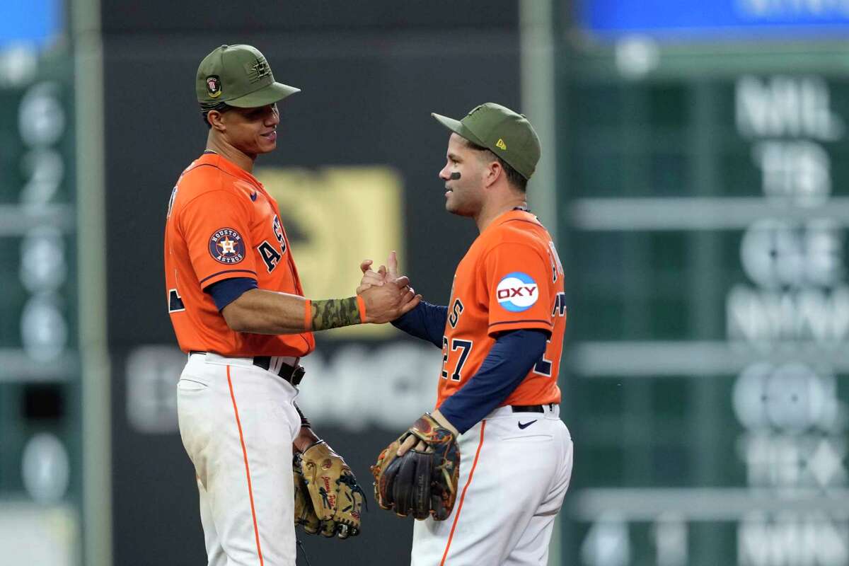 Houston Astros' Jose Altuve (27) and Jeremy Pena celebrate after a baseball game against the Oakland Athletics Friday, May 19, 2023, in Houston. The Astros won 5-1.