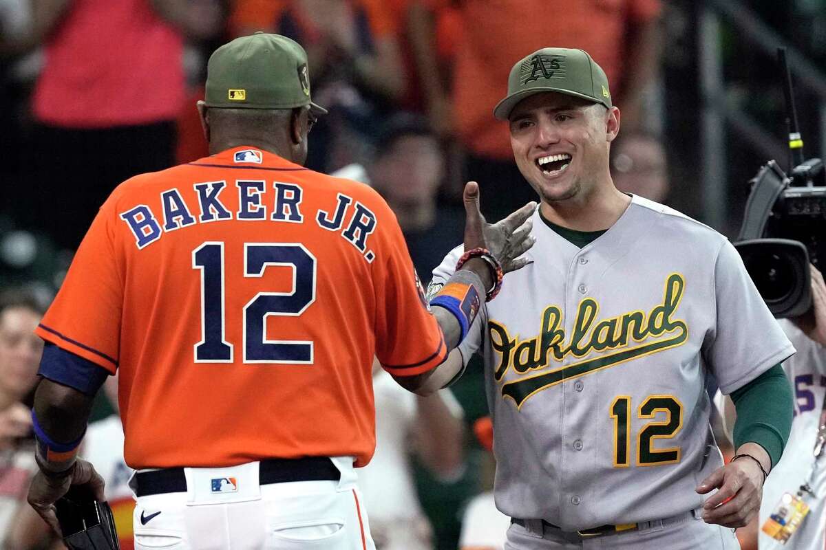 Houston Astros' Dusty Baker Jr., left, greets Oakland Athletics' Aledmys Diaz to present him his 2022 World Series Championship ring before before a baseball game Friday, May 19, 2023, in Houston.
