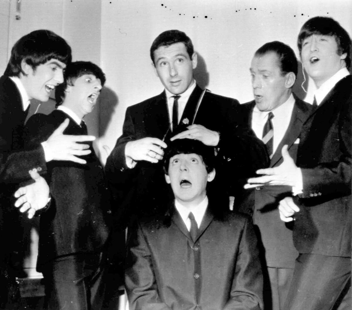FILE - American speed skating champion Terry McDermott, background center, a barber by trade, prepares to take a swipe at the famed locks of Beatle Paul McCartney, seated , to the mock horror of the other Beatles and TV host Ed Sullivan, during rehearsals at the TV Studio, New York, Feb. 9, 1964. From left, George Harrison, Ringo Starr, McDermott, Ed Sullivan and John Lennon. McDermott, who won the only gold medal for the United States at the 1964 Winter Olympics, died on Saturday, May 20, 2023, U.S. Speedskating said. He was 82.