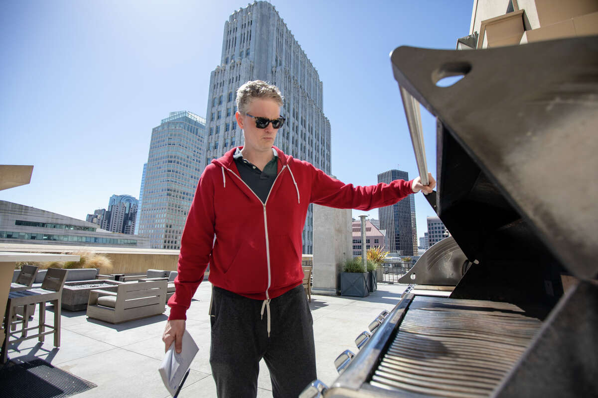 SFGATE columnist Drew Magary checks out the rooftop shared deck of a condominium available for sale on New Montgomery Street in the SOMA in San Francisco, Calif. on May 14, 2023.