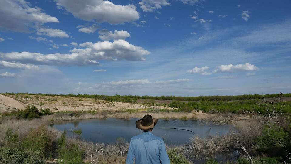 Rancher Schuyler Wight looks over a sinkhole near Highway 1053 Wednesday, April 26, 2023 in Imperial. The sinkhole happened following TxDOT filling in a well near the roadway.