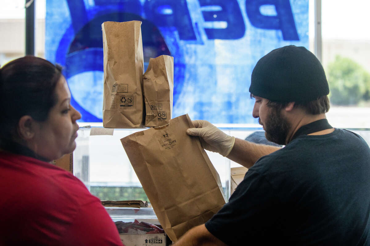 (Left to right) Alejandra Nayeli Perez and Ryan Organ prepare to go orders at Bud's Giant Burgers in Vallejo, Calif. on May 24, 2023.