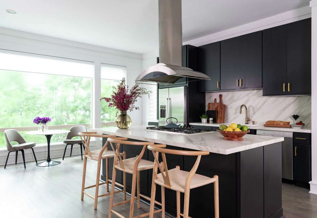 Houston interior designer Missy Stewart refreshed her kitchen by installing new counters and backsplash using Neolith's Calacatta Gold. She painted the cabinets Sherwin-Williams Tricorn Black and used oversized brass hardware for a bolder contrast.