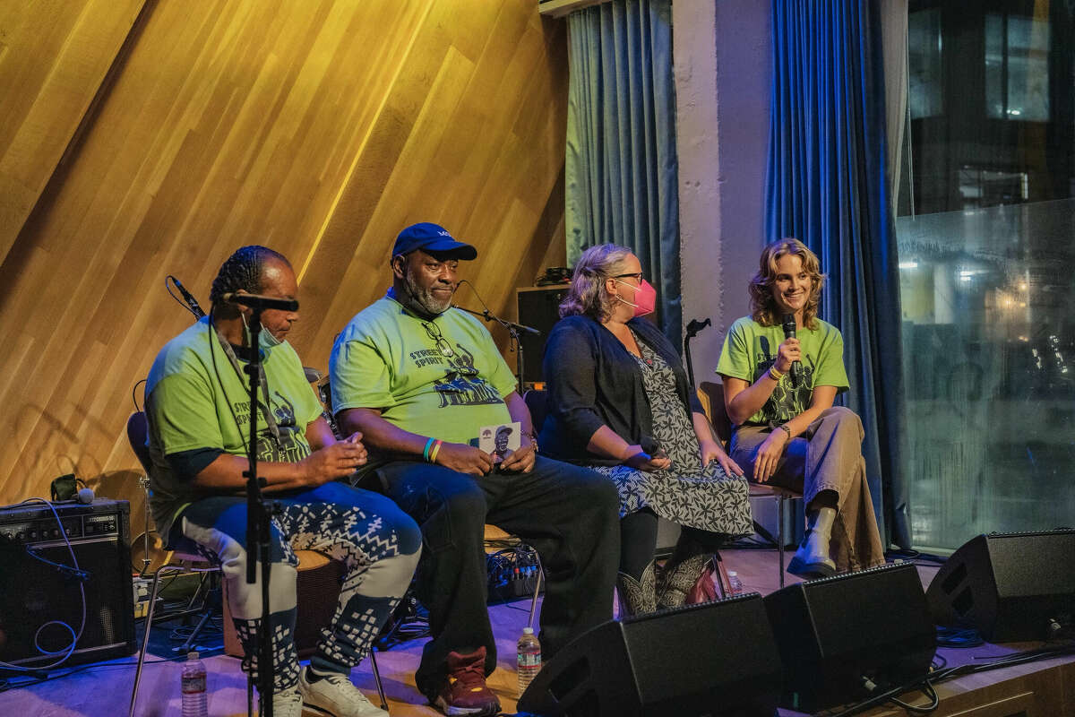 From left to right, Street Spirit vendors Vernon Dailey and Derrick Hayes, local homeless advocate and Love and Justice in the Streets founder Talya Husbands-Hankin and Street Spirit editor Alastair Boone sit on stage during a Street Spirit fundraising concert at Bandcamp in Oakland in November 2022. 