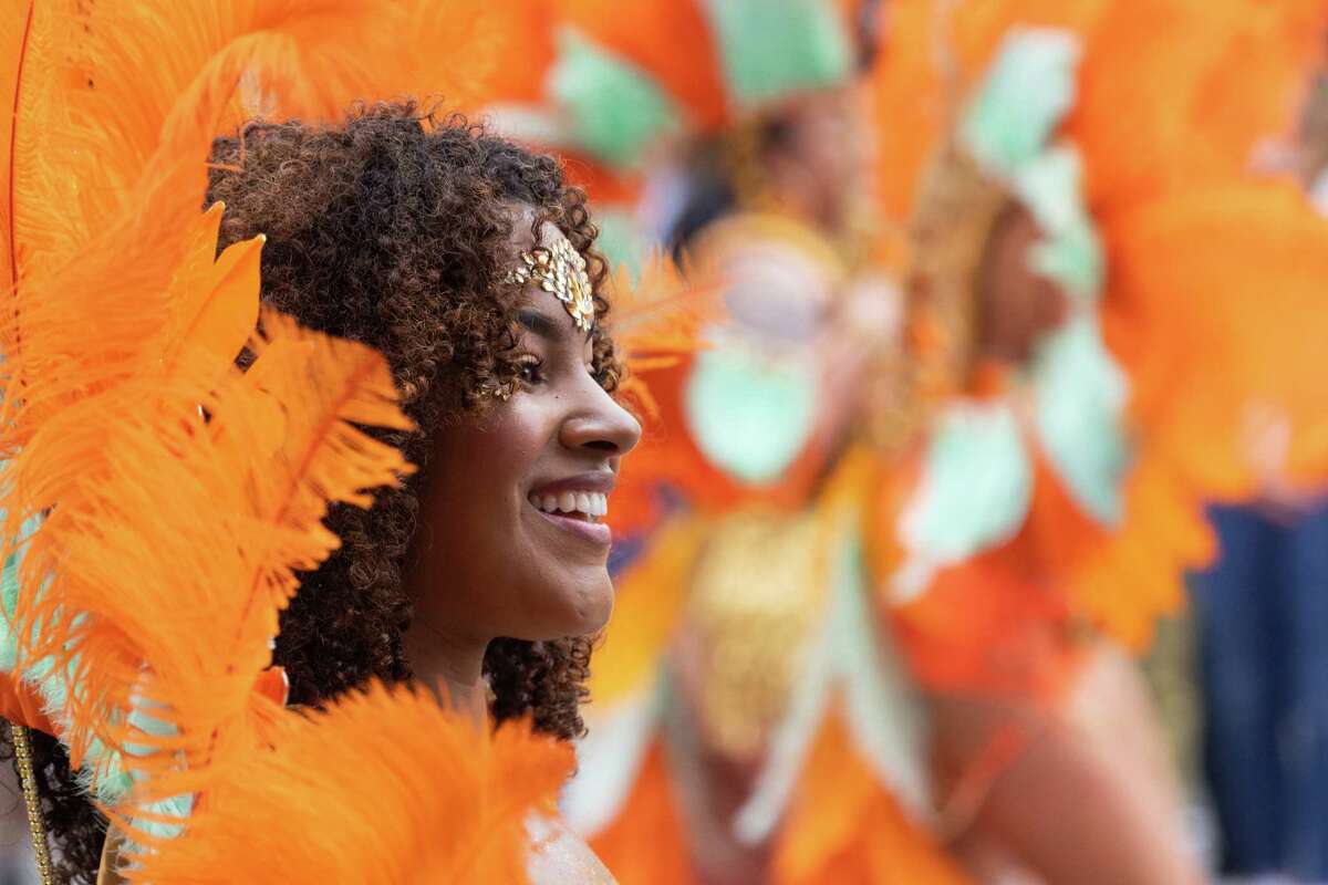 Un participante del Gran Desfile del Carnaval sonríe mientras marcha en grupo por Mission Street en San Francisco, California, el domingo 28 de mayo de 2023.
