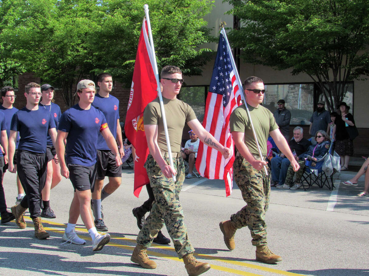 A group of Marines carrying a U.S Marine Corps flag and an American flag march down Main Street during the Memorial Day parade on May 29, 2023 in Midland. 