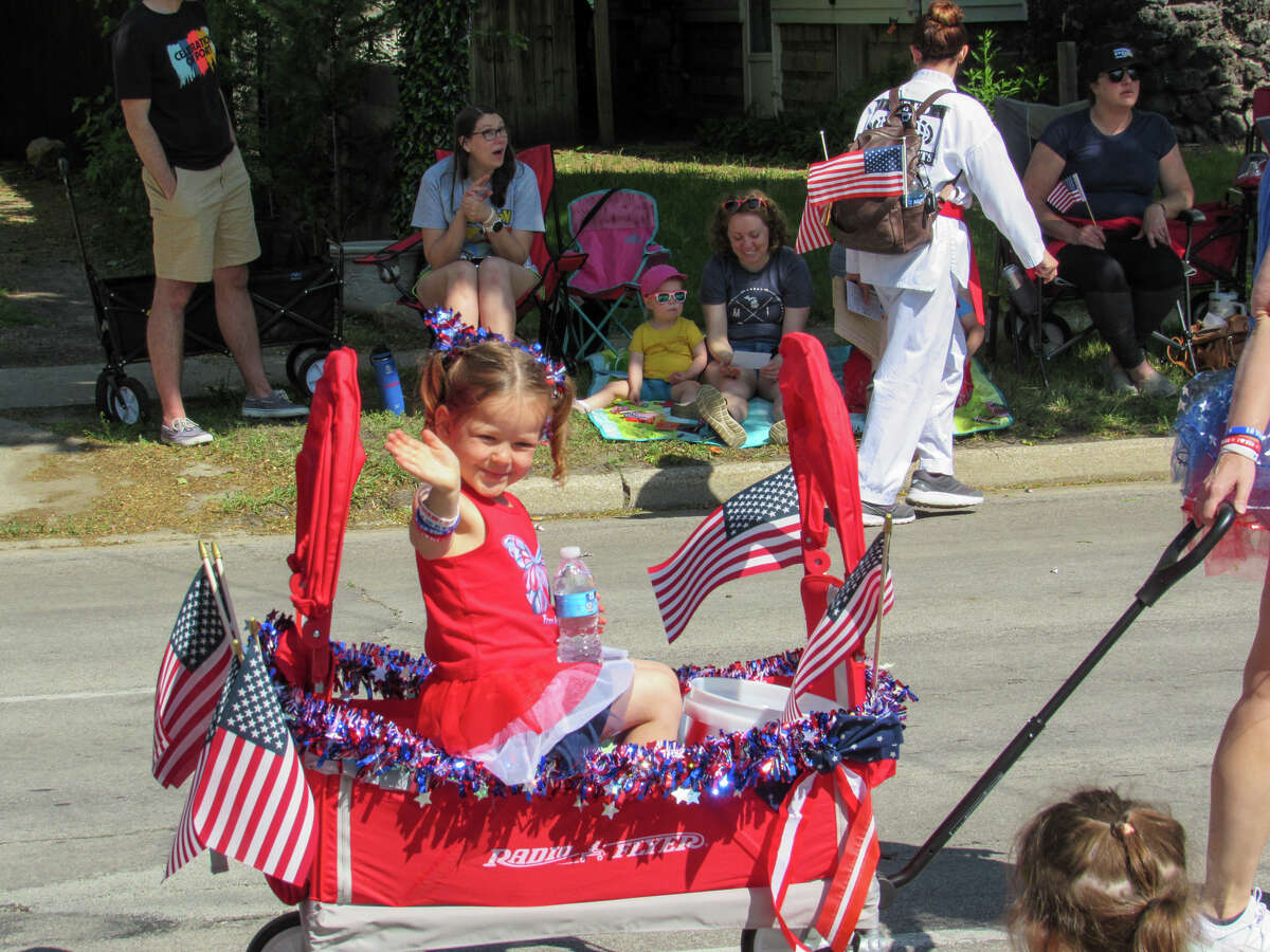A child waves to the crowd from her wagon during the Memorial Day parade on May 29, 2023 in Downtown Midland. 