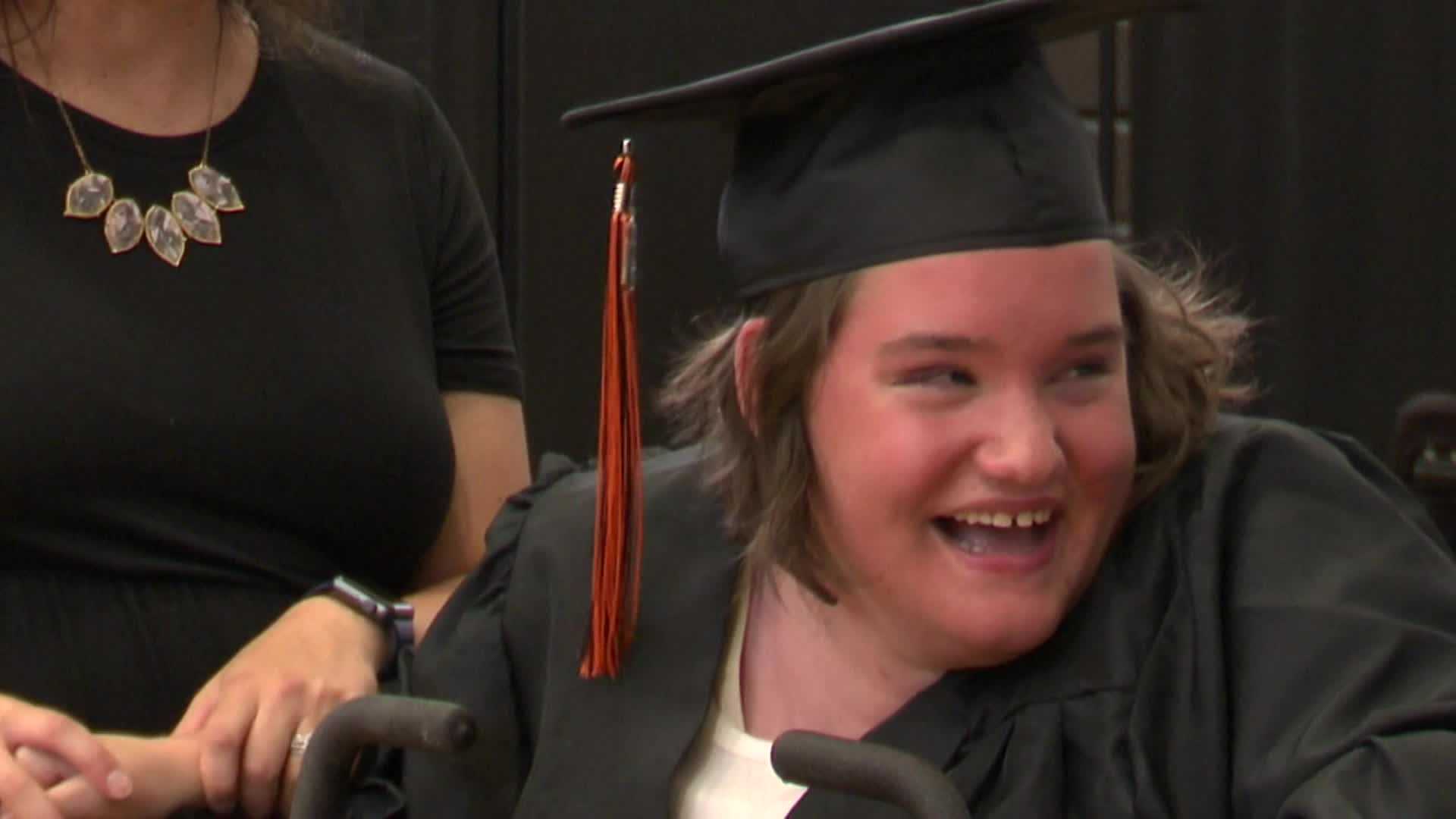 high-school-graduate-walks-in-commencement-ceremony-with-help-from