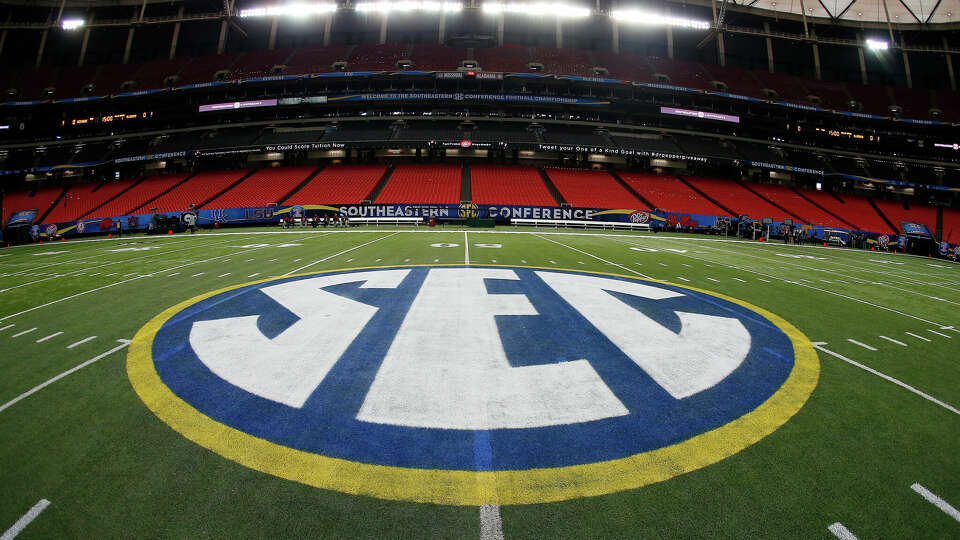 FILE - The SEC logo is displayed on the field ahead of the Southeastern Conference championship football game between Alabama and Missouri on Dec. 5, 2014, in Atlanta. Southeastern Conference leaders will continue debating what to do with their football schedule when they meet in the Florida Panhandle starting Tuesday, May 30, 2023. (AP Photo/John Bazemore, File)