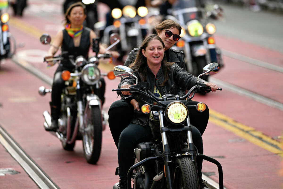 A couple rides together at the Dykes on Bikes event on June 26, 2022 in San Francisco, Calif. 