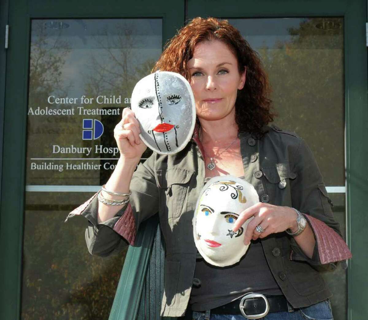 Carolyn Kelly-Winter, an expressive art therapist for The Center for Child and Adolescent Treatment Services, in Danbury, holds masks she made for drama therapy sessions on Tuesday, Oct. 19, 2010.