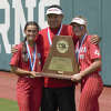 Coahoma seniors Christian Everett, left and Shae Lang, right, hold the state championship trophy with their head coach Alexander Orosco, June 1 at Red and Charline McCombs Field in Austin. 
