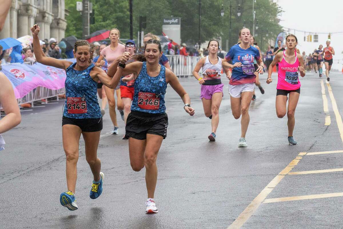 Christie Gebauer, left, and Megan Linendoll finish the 45th Freihofer’s Run for Women on Saturday, June 3, 2023, in Albany, NY.