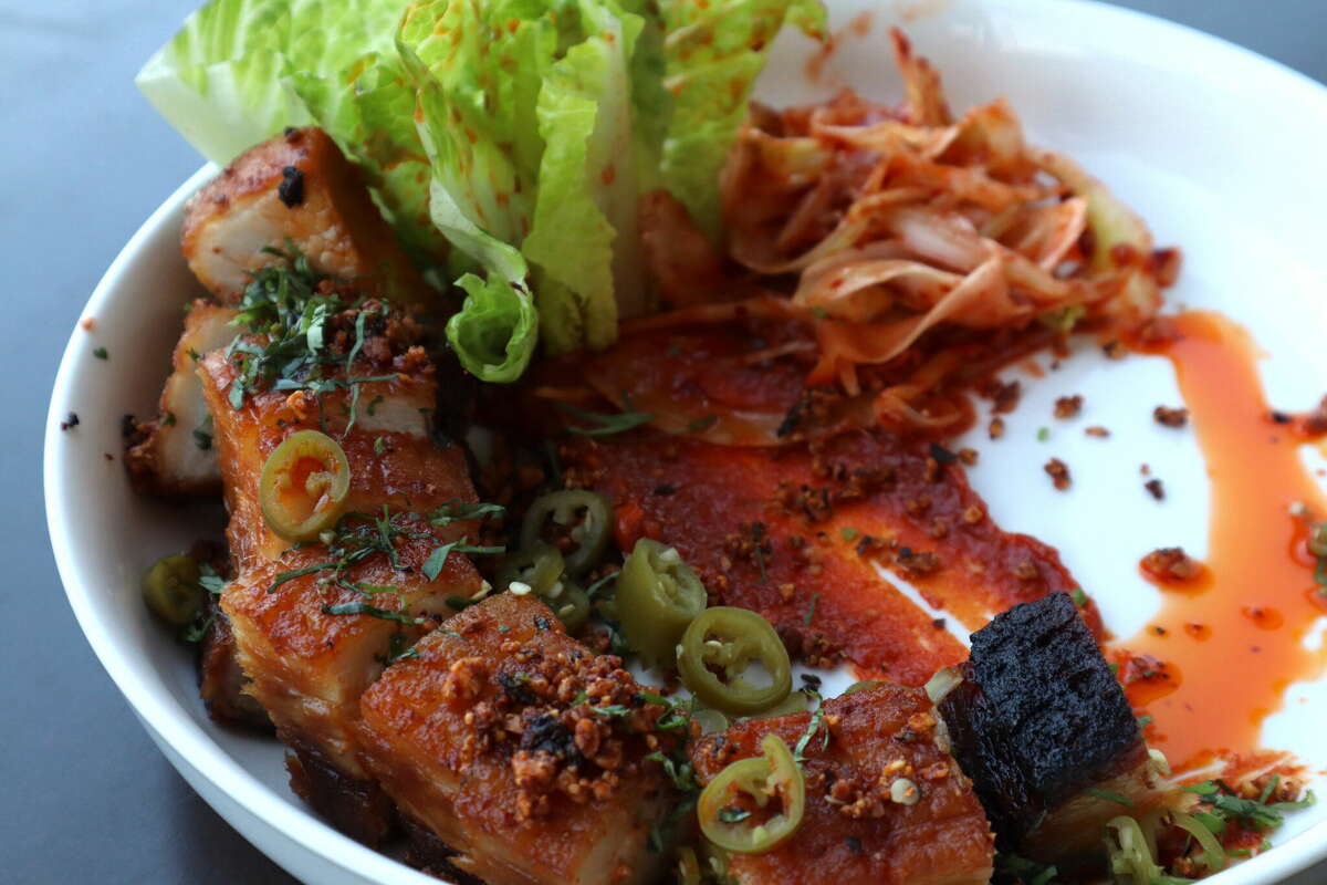 Crispy pork belly ssam with chile peanut, fennel slaw, pickled Serrano, chile oil, cilantro and "flashy trout back" speckled romaine. 