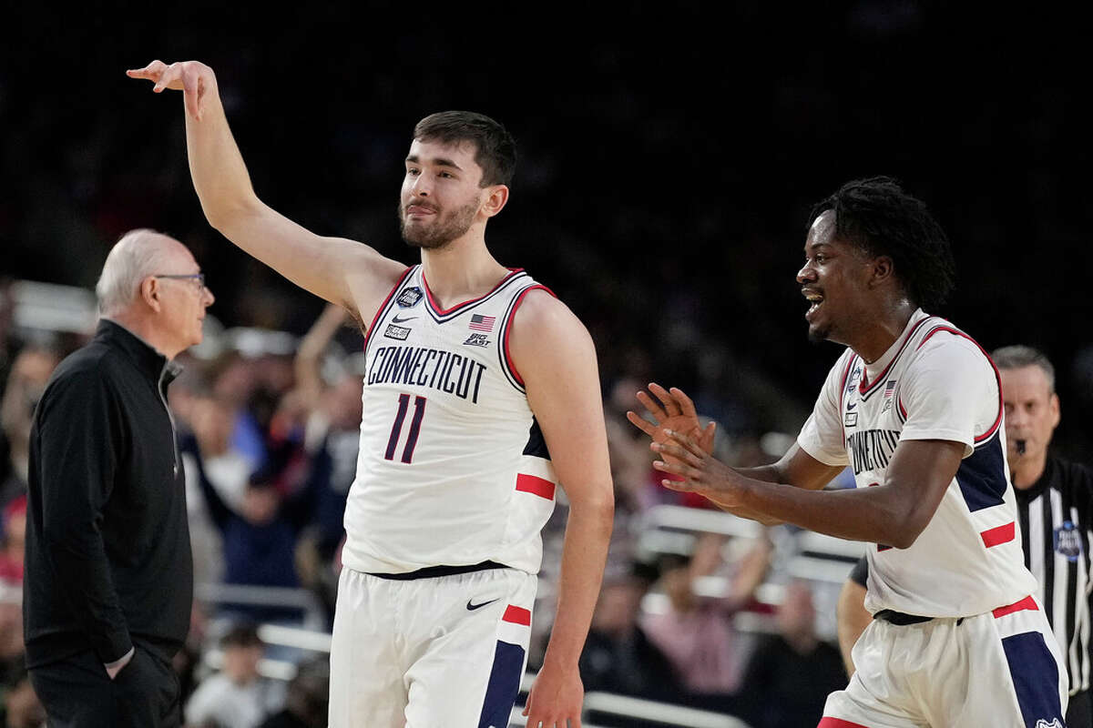 Connecticut forward Alex Karaban (11) celebrates with Tristen Newton after a three pointer at the halftime buzzer of a NCAA Tournament national semifinal game against Miami at NRG Stadium on Saturday, April 1, 2023, in Houston.