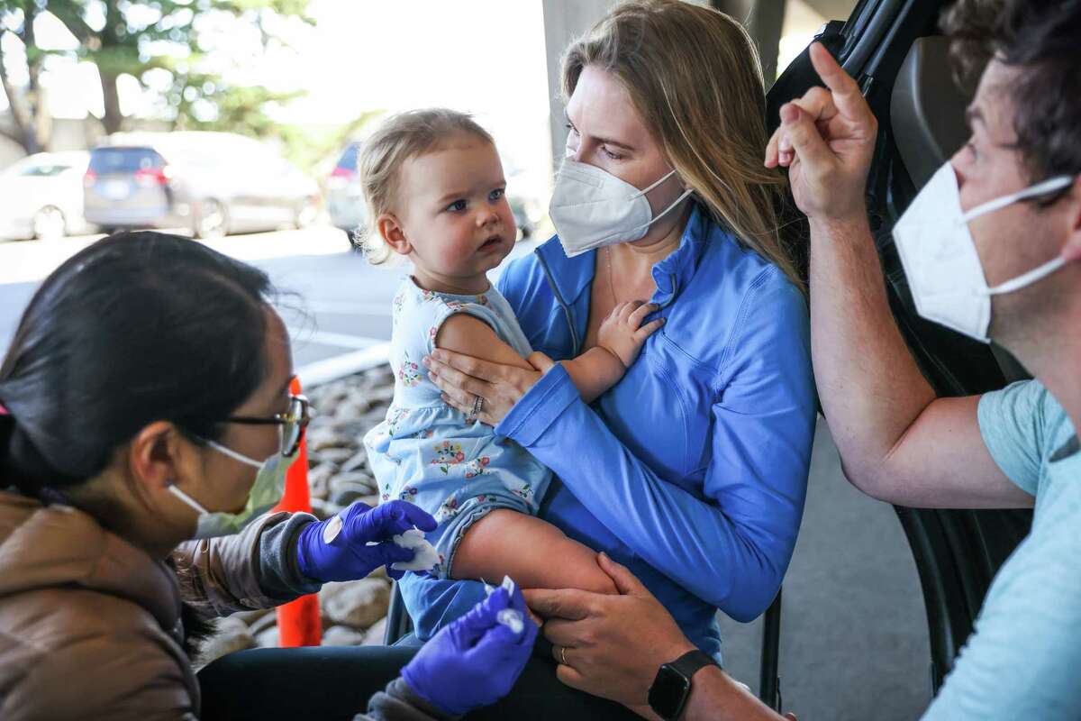 Elizabeth Goffinet embraces daughter Wesley as the 16-month-old gets her first vaccine in June 2022. Kaiser Permanente researchers have found no link between mRNA COVID vaccines and 23 potential side effects for infants and toddlers.